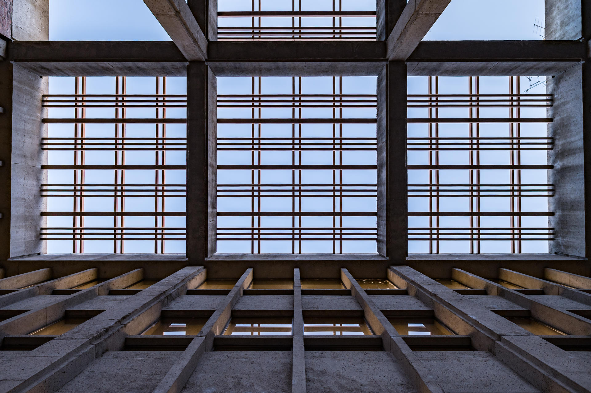 A photo from the ground looking up at intersecting bars beneath a library.