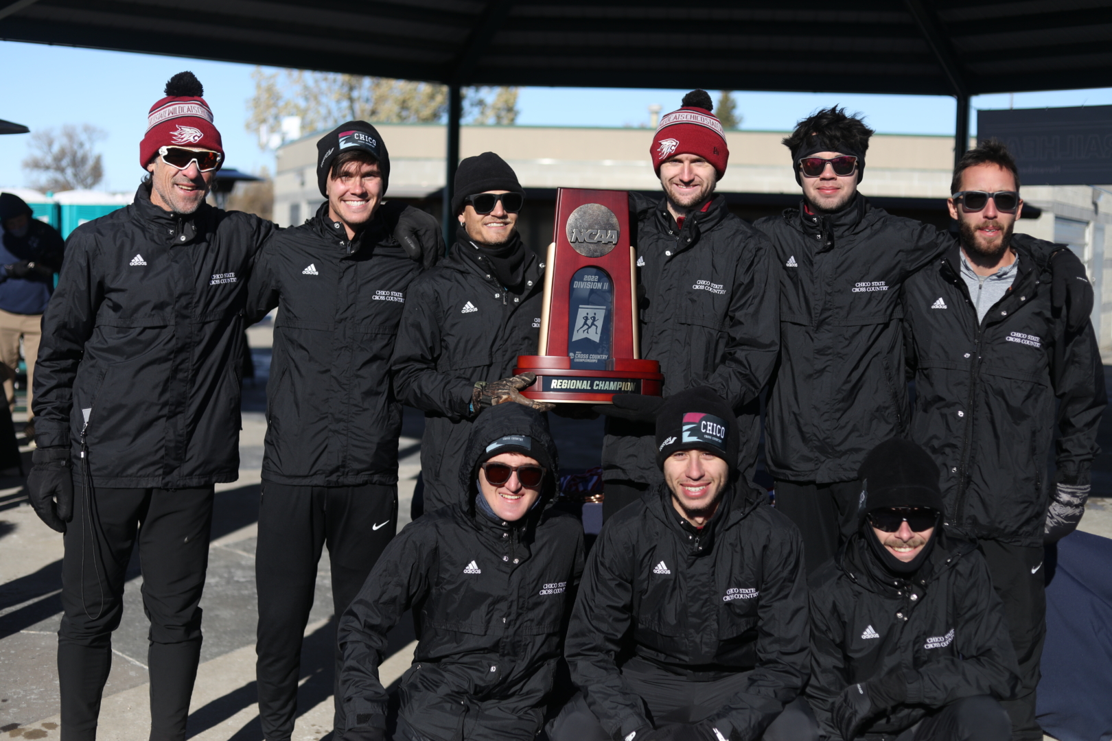 Rory Abberton (middle) helps hold the NCAA West Regional Championship trophy as he and his teammates pose.