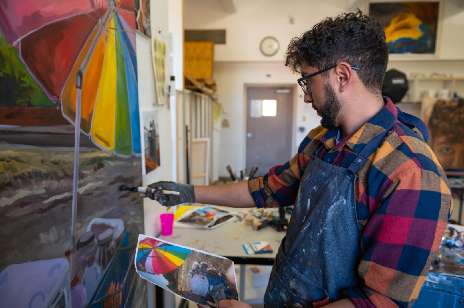 Joel Solis used a paintbrush to touch up his painting of a Latina street vendor.