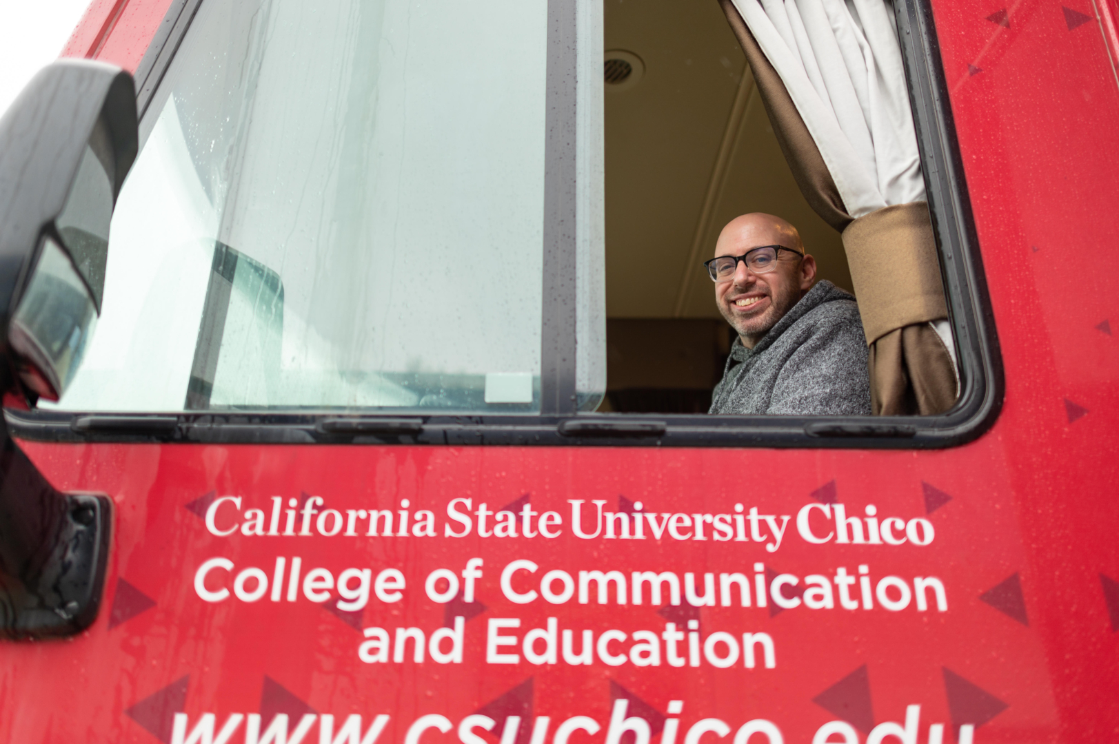 Tal Slemrod smiles while sitting in the front seat of the Mobile Classroom.