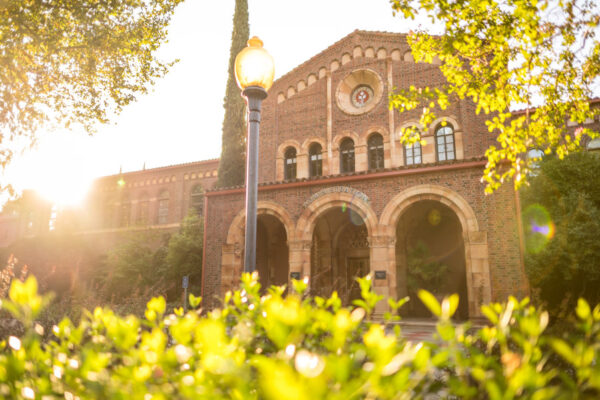 the sun sets behind an academic building