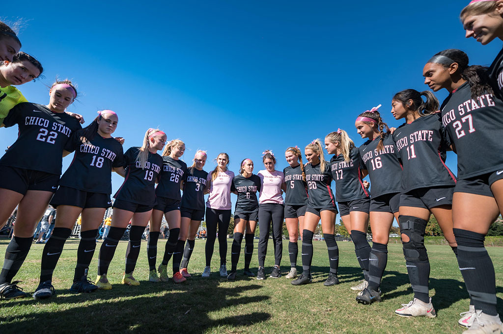 The 2022 Chico State women's soccer team huddles prior to a match,