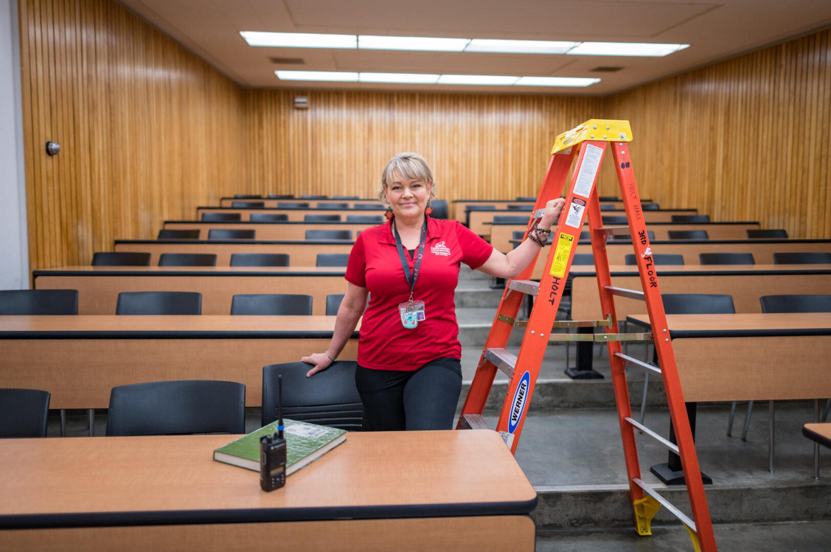 Lore leans her arm on a ladder inside a college classroom