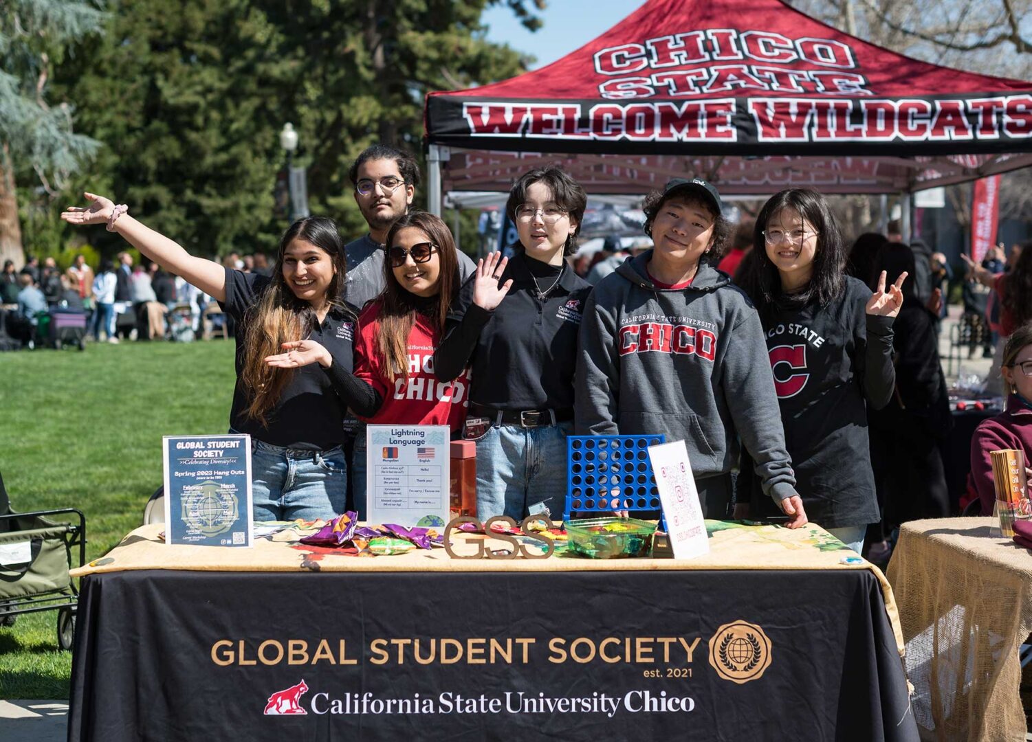 International students in the Global Student Society pose at their table during the annual Choose Chico event on campus during a sunny April afternoon.