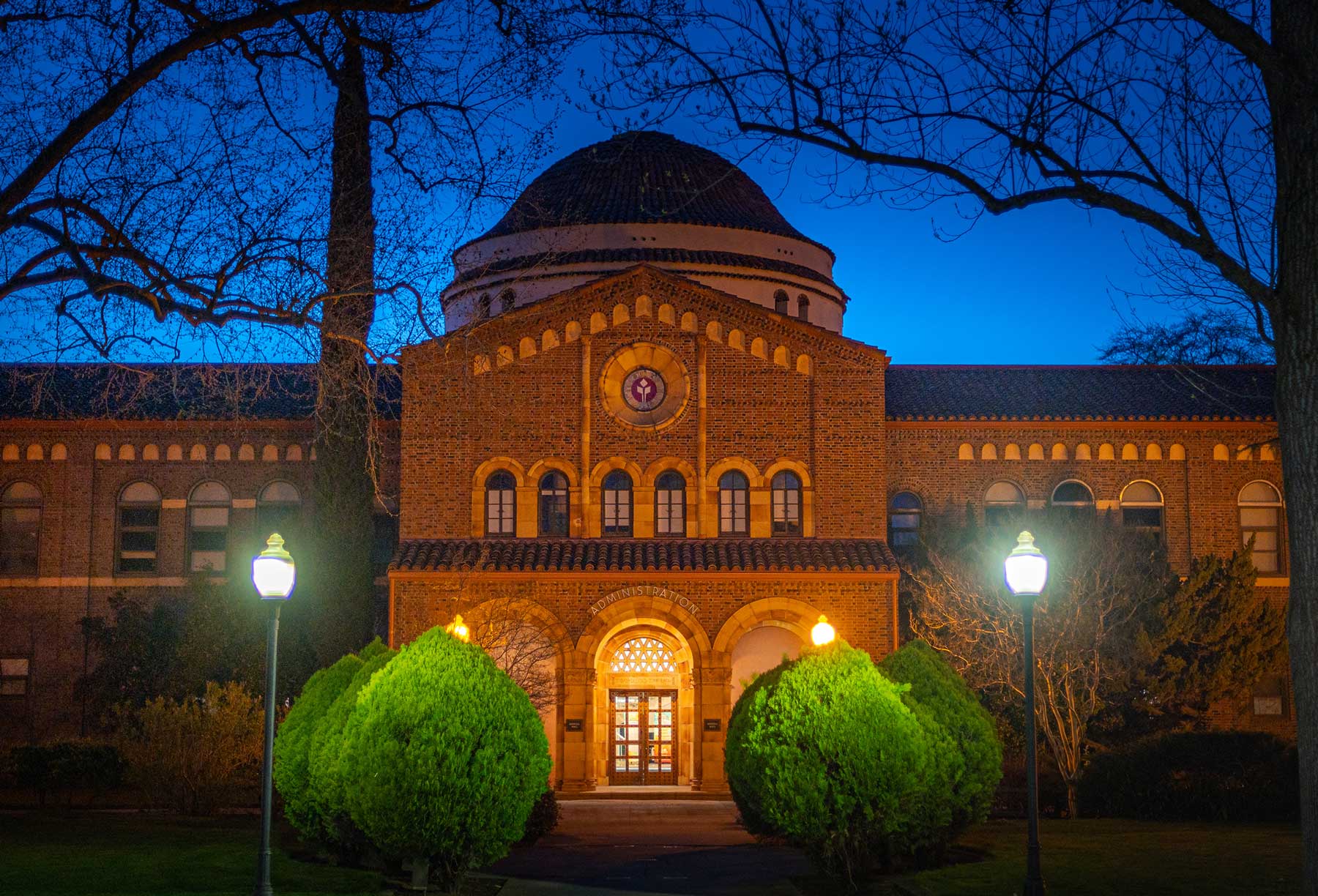 Kendall Hall is photographed at dusk, illuminated by soft lights against a cobalt blue sky.