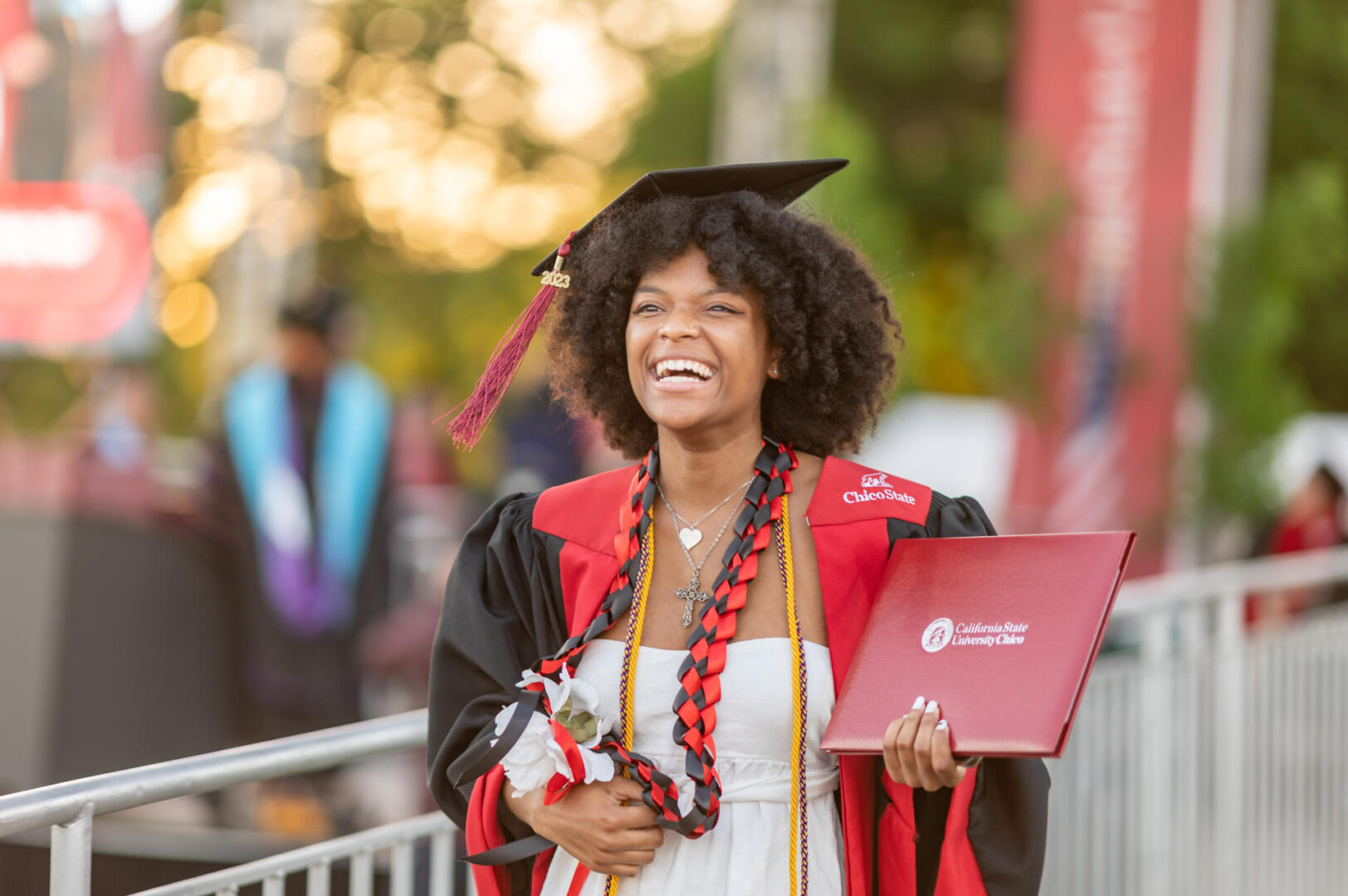A college student holds her diploma and smiles as she celebrates graduating from college
