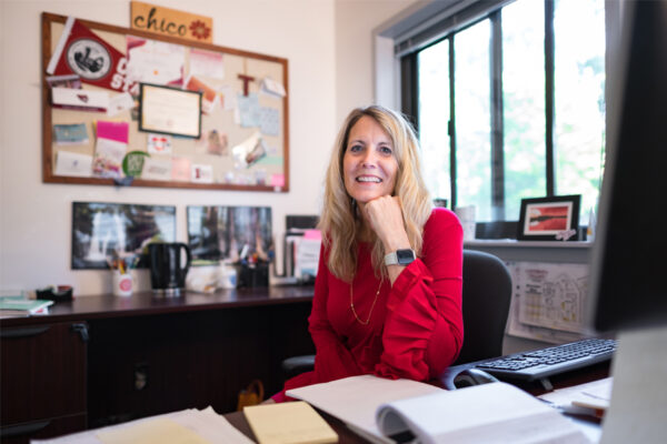 Tami Henriksen smiles while sitting at her desk