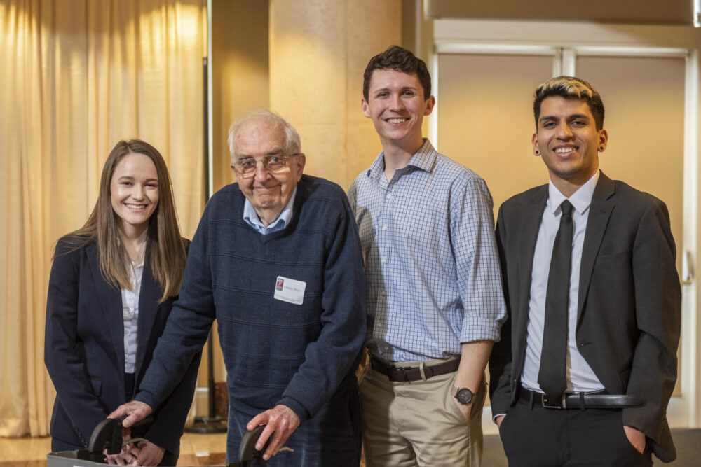 Four people stand next to each other for a posed photo, including Professor Emeritus Charles Price, who is the second from left. 