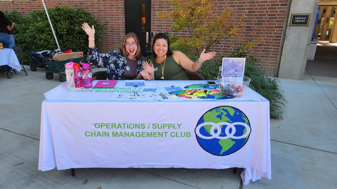 OSCM club members pose while tabling on campus