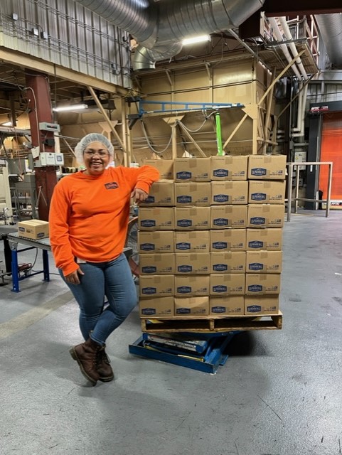 Lupita Aramburo poses next to packaging in the Lundberg Family Farms factory.