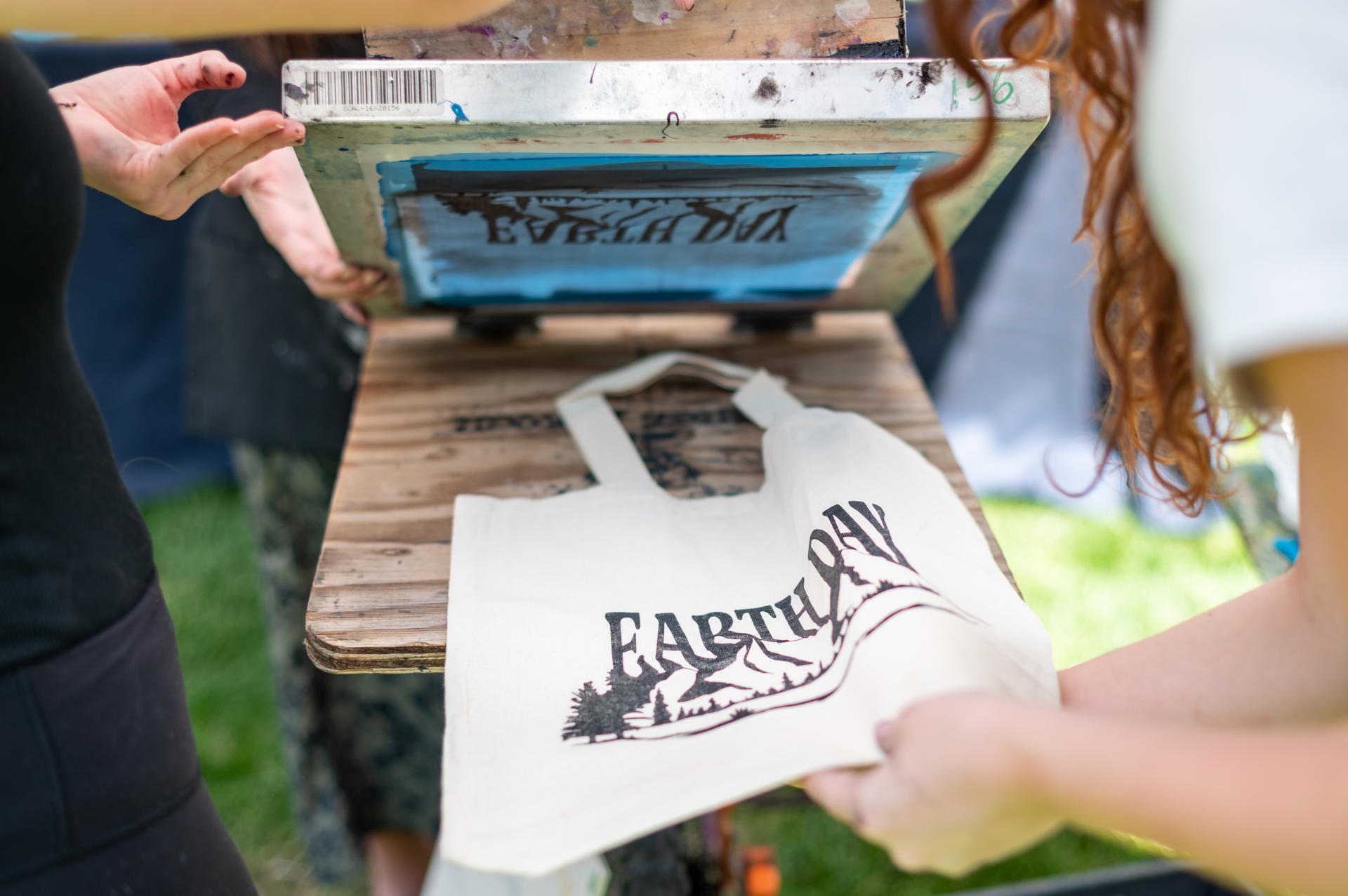 A printing machine puts an Earth Day logo on a reusable bag