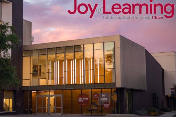 An academic building at dusk with the words "Joy of Learning, California State University, Chico"