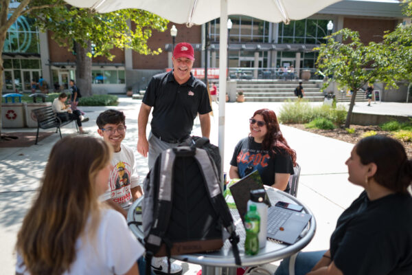 President Perez shares a laugh with a group of students on the first week of school after asking them their majors and what made them choose Chico.