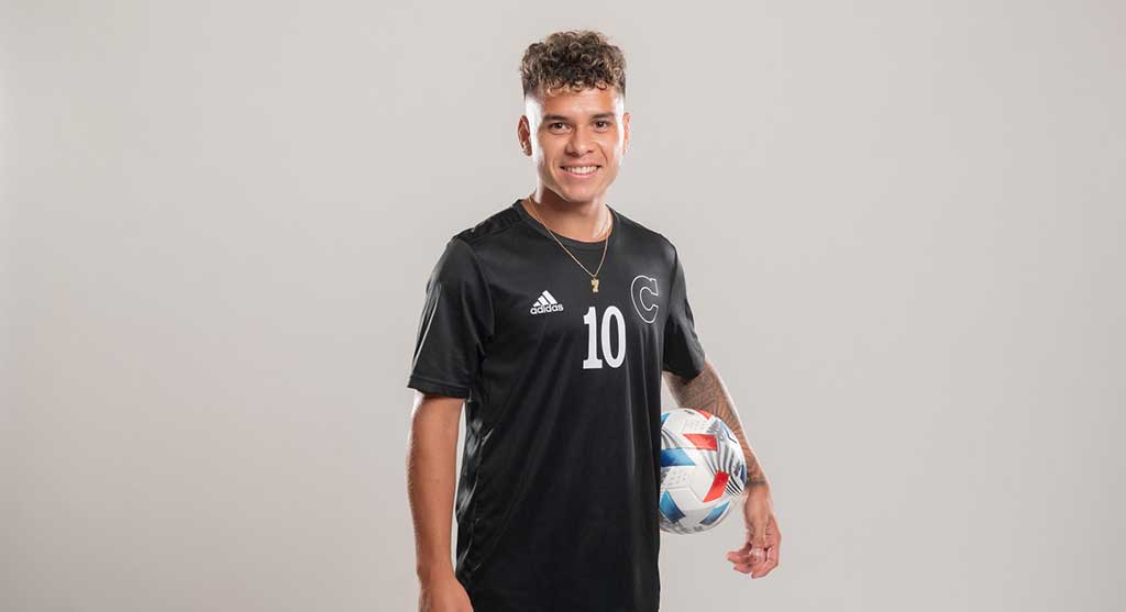 Adrian Fontanelli poses for a portrait with a soccer ball between his left arm and hip.