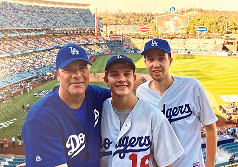 President Perez with his two sons, all wearing Dodgers jerseys and hats, at a game.