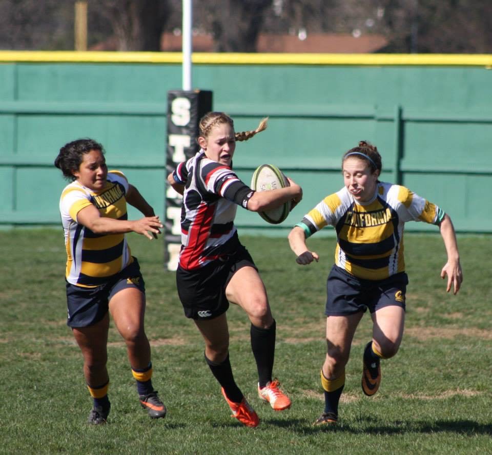 Megan Foster splits two Cal rugby defenders while competing for Chico State.