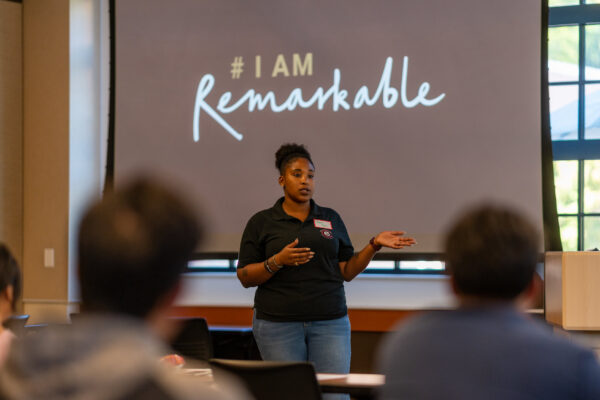 Cherie Higgs presents in front of a screen that reads, "I am remarkable."