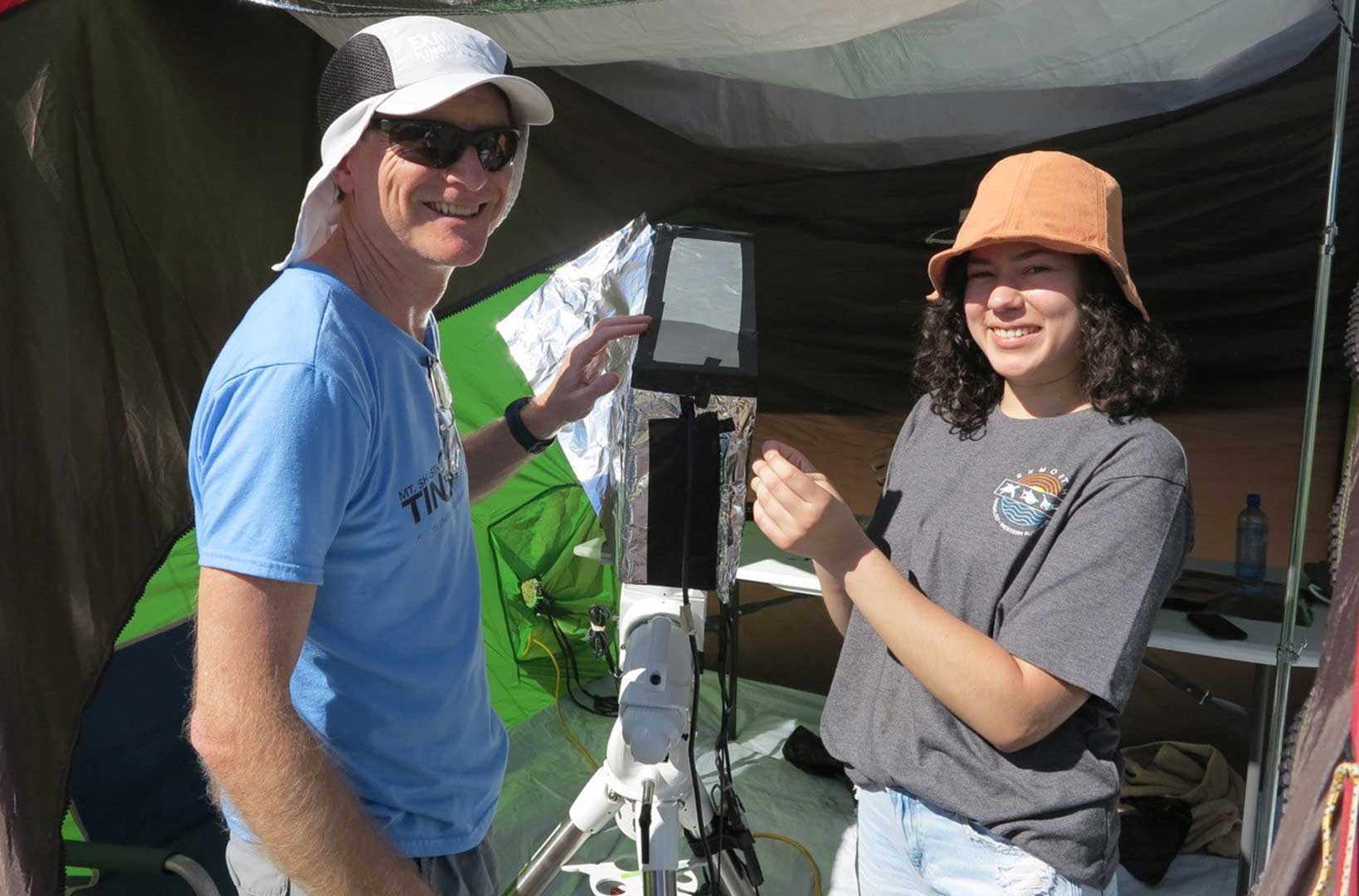 Eric Ayars (left) and Danielle Casillas are standing beside a spectrometer, which they will use to gather data during a solar eclipse.  