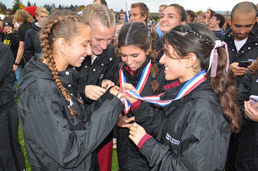 Twin sisters Della and Iresh Molina show off their All-West Region medallions to their teammates.