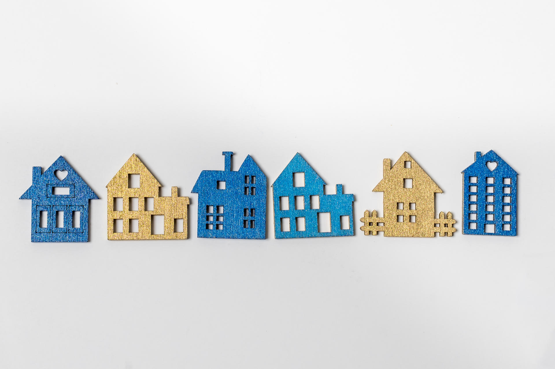 Colorful wooden cutouts of houses on a white background