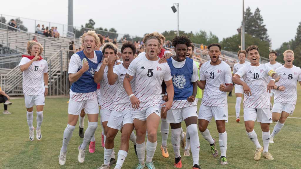 Members of the 2023 Chico State men's soccer team celebrate a goal by number 5 Miles Rice.