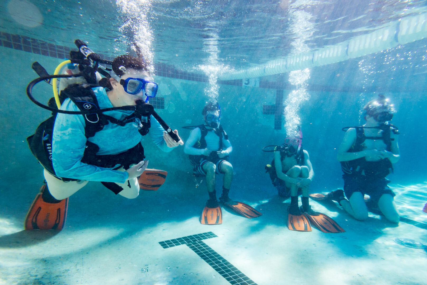 A group of students is photographed scuba diving at a pool on the Chico State campus.