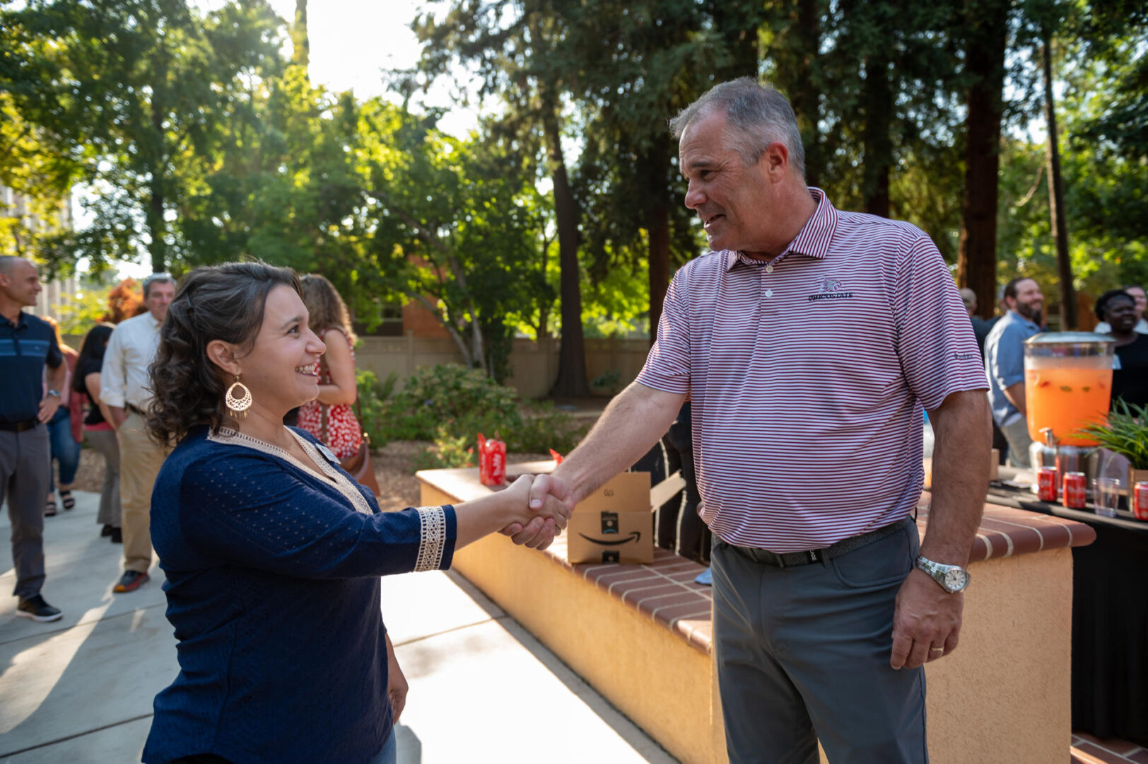 Tiffany Drobny shakes the hand of Steve Perez (right) during a fall President open house event.