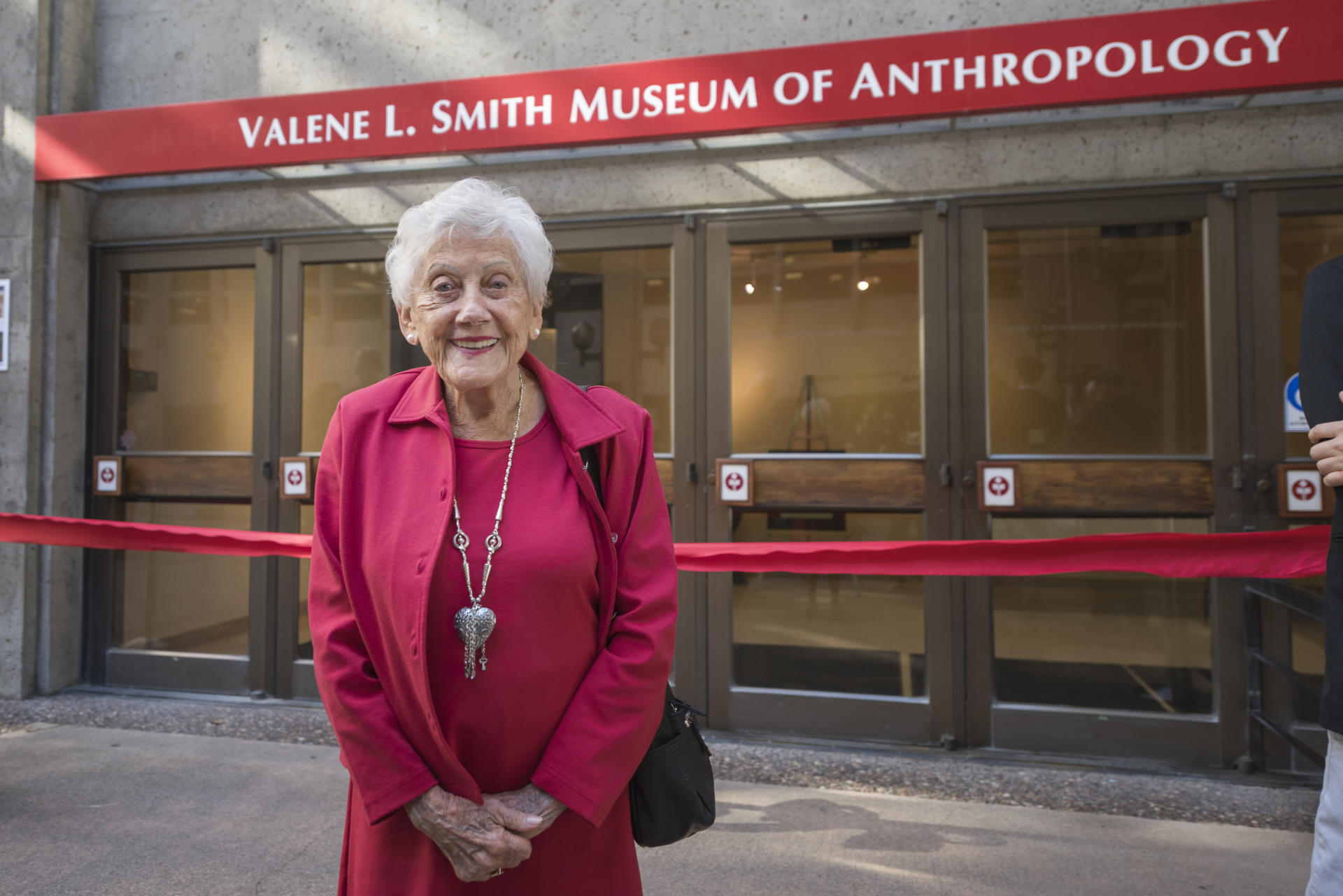 Valene. L Smith stands in front of the Museum bearing her name.