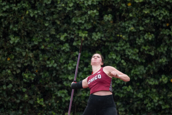 An athlete in a Chico State track uniform prepares to throw a javelin.