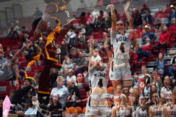 Brandy Huffhines rises to shoot over a leaping defender in this artistic double-image photo.