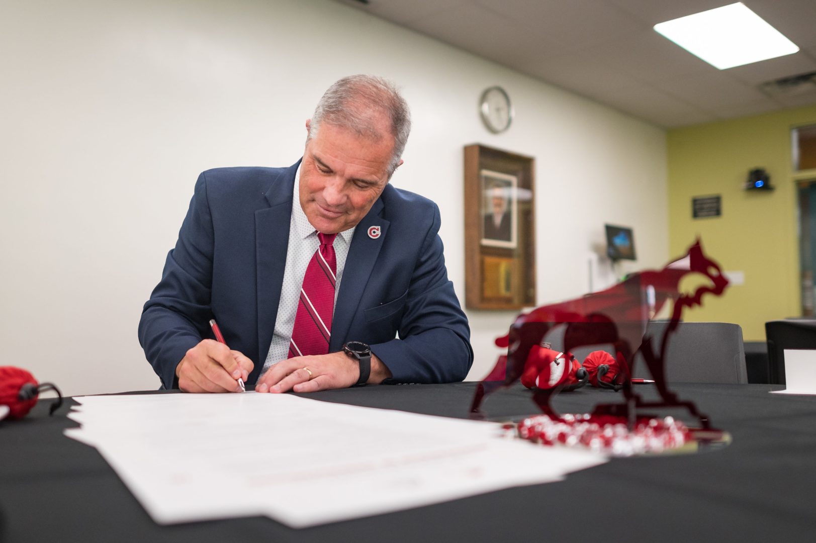 President Perez signs a stack of MOUs with each community college.