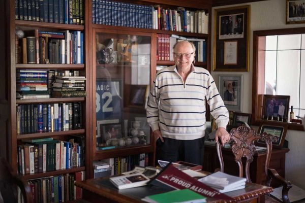 Dan Ostrander in his home office, surrounded by books, framed artifacts and photos, and autographed memarobilia.