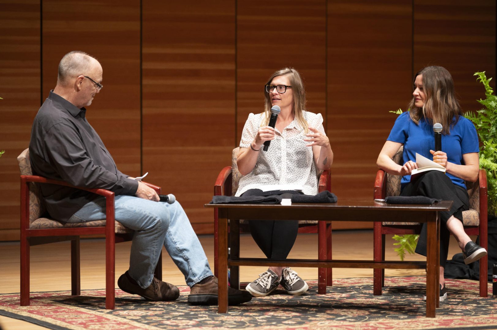Dr. Sarah Ray and Dr. Jennifer Atkinson sit with Mark Stemen on a stage while discussing their book during a moderated event.