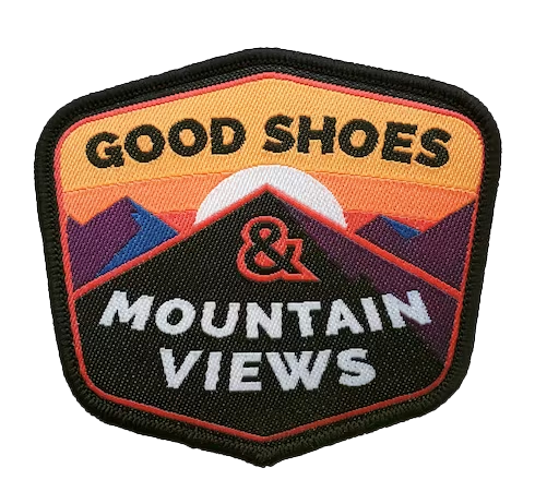 A patch that reads "Good Shoes & Mountain Views" and depicts a mountain peak with a sun setting behind it.
