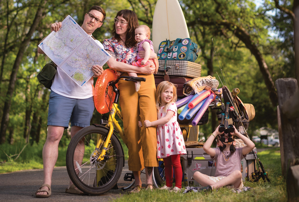 A family with a bike filled with summer adventure gear.