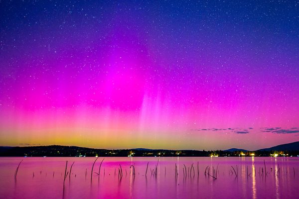 The Northern Lights glow over the surface of Lake Almanor