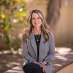 Chico State Alumni Board President Kristen Schrock sits with her hands in her lap, posing for a headshot on campus at the University.