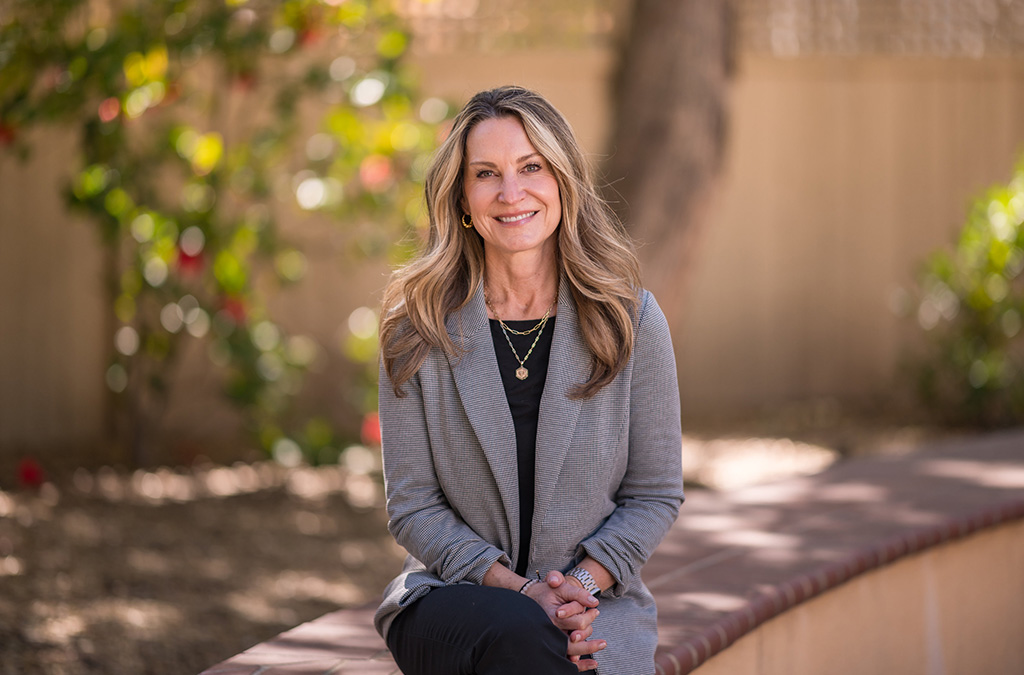 Chico State Alumni Board President Kristen Schrock sits with her hands in her lap, posing for a headshot on campus at the University.