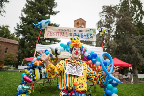 A clown creates fish balloons at the cybersecurity-themed carnival Festival of the Phishes on campus at Chico State.