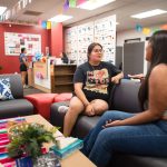 Two students sit on a couch to chat.