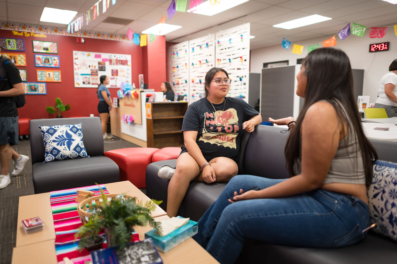 Two students sit on a couch to chat.